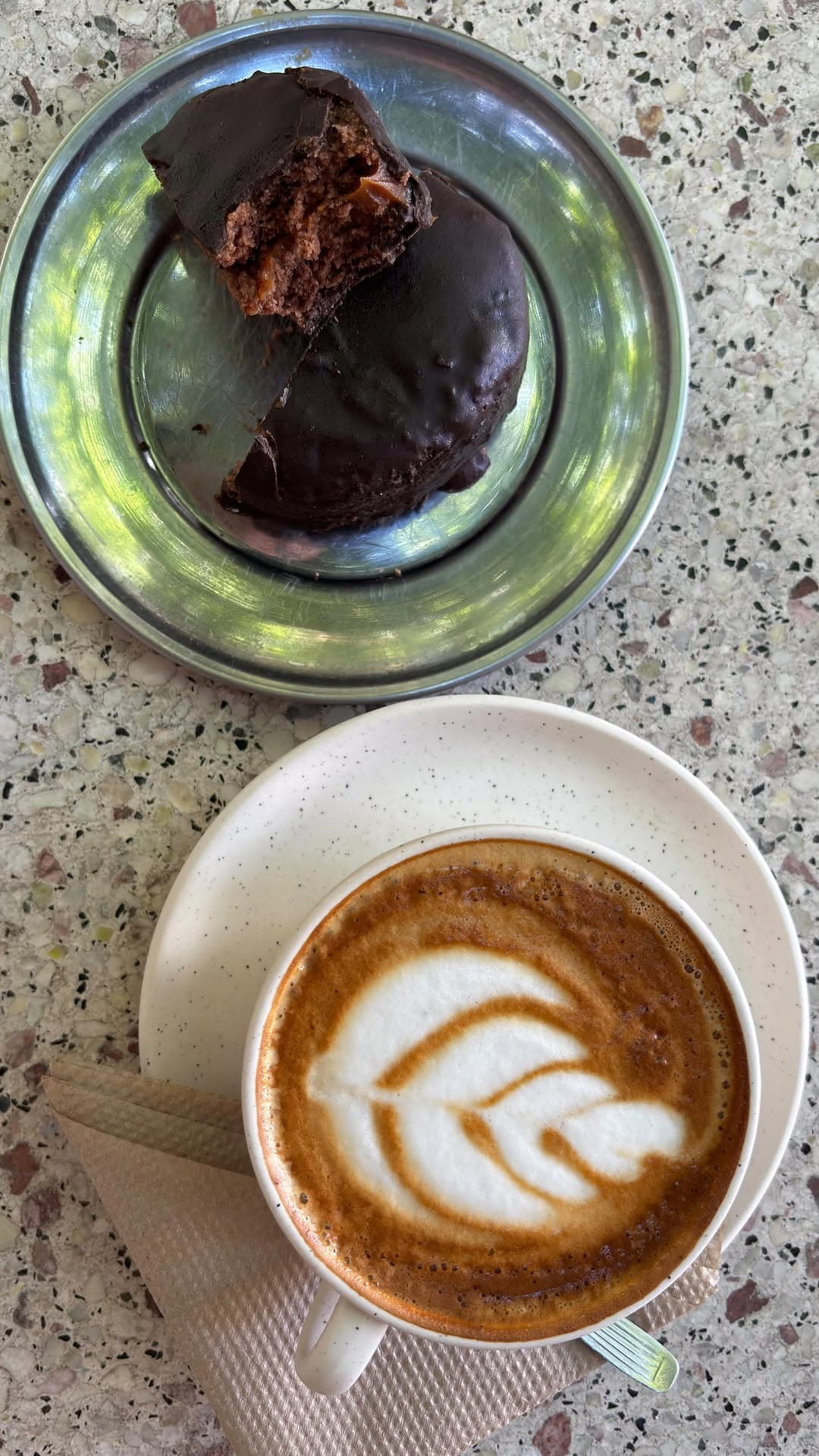 Alfajor de chocolate y dulce de leche junto a un latte